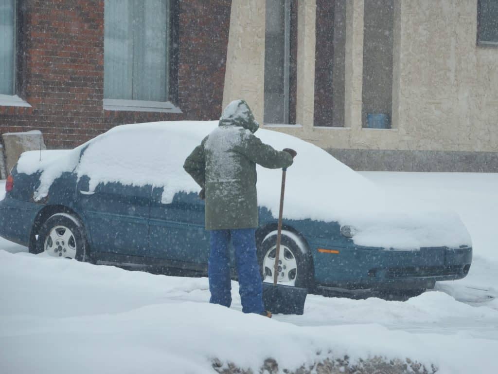 Clearing a car with snow.