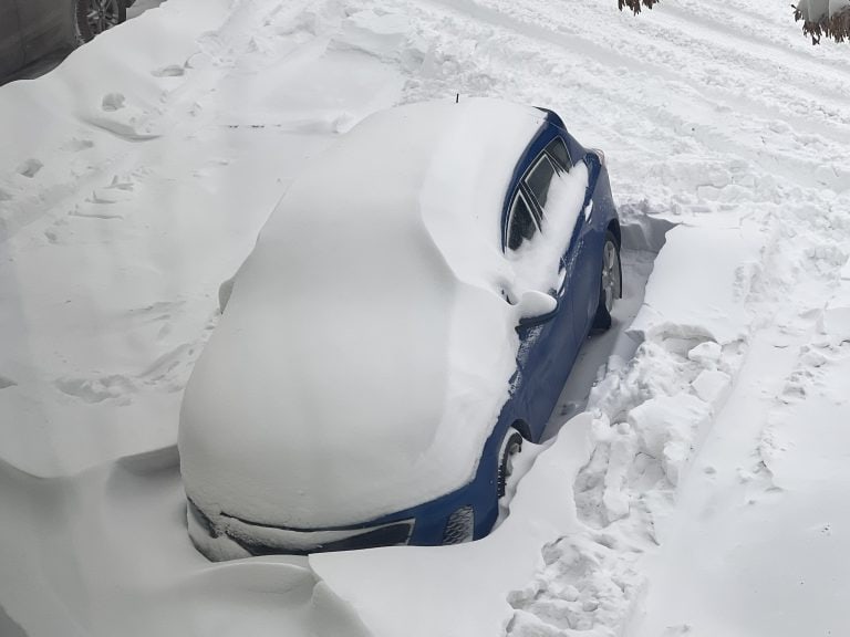 A vehicle buried in the snow.