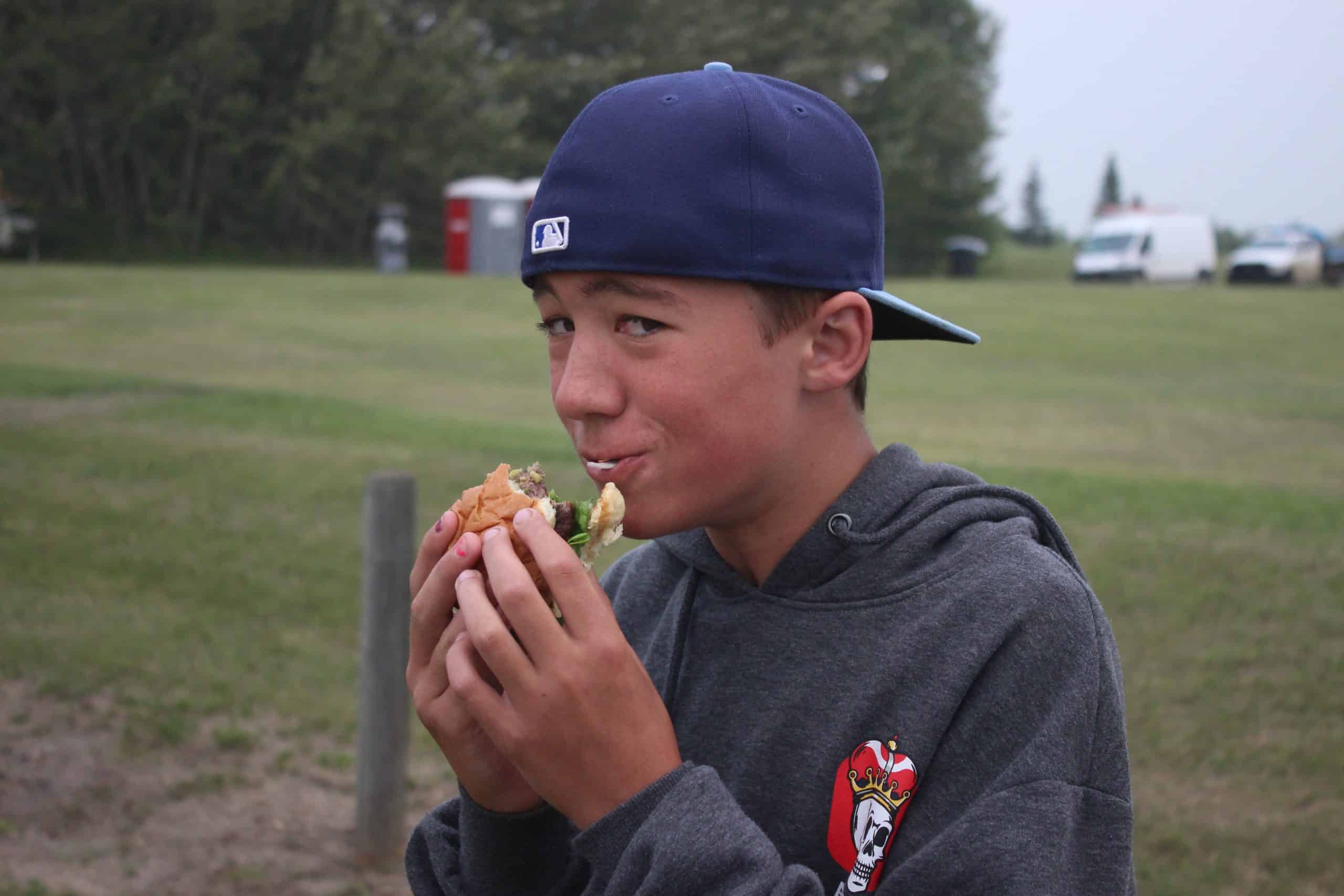 Kid eating a burger.
