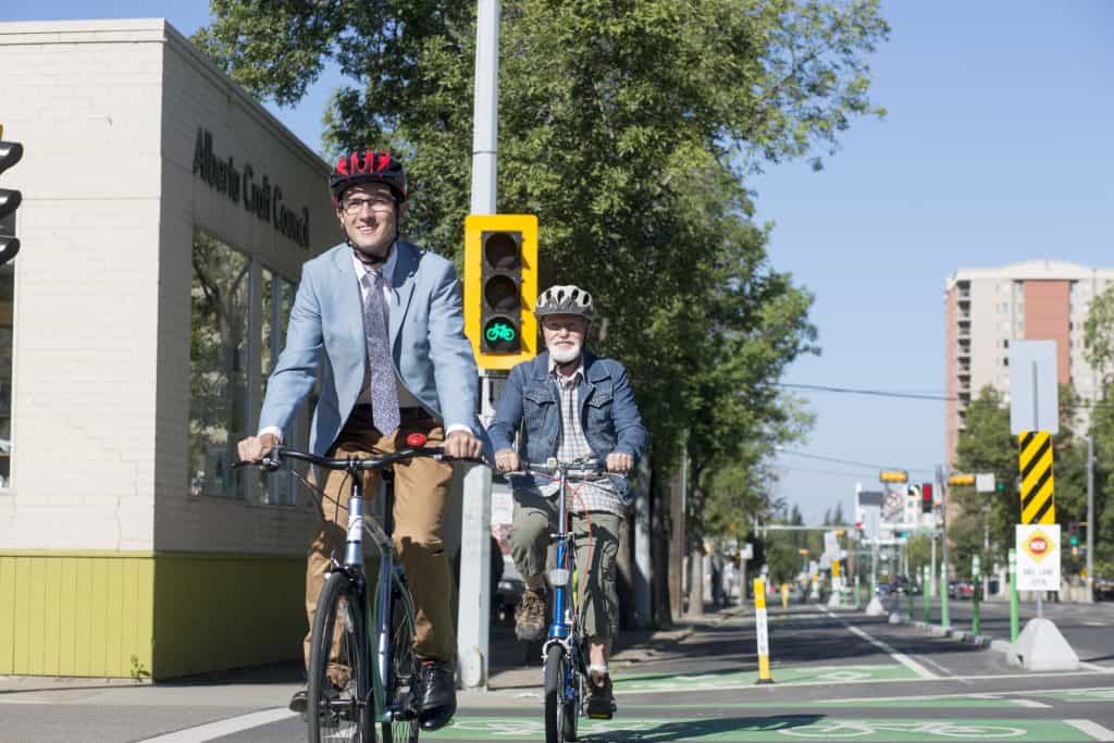 Two people riding bikes in summer.